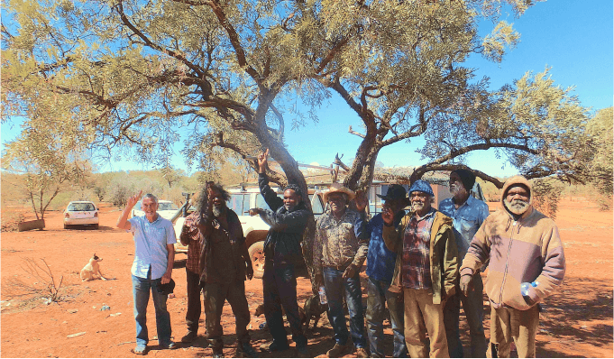 A photo of Anthropologist Richard Moyle standing with a group of men in Alyawarr country