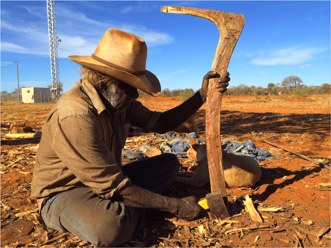 A photo of Frank Holmes carving a number 7 boomerang.